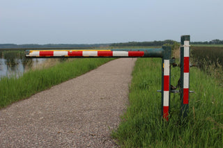 A road barrier near water with clear skies.