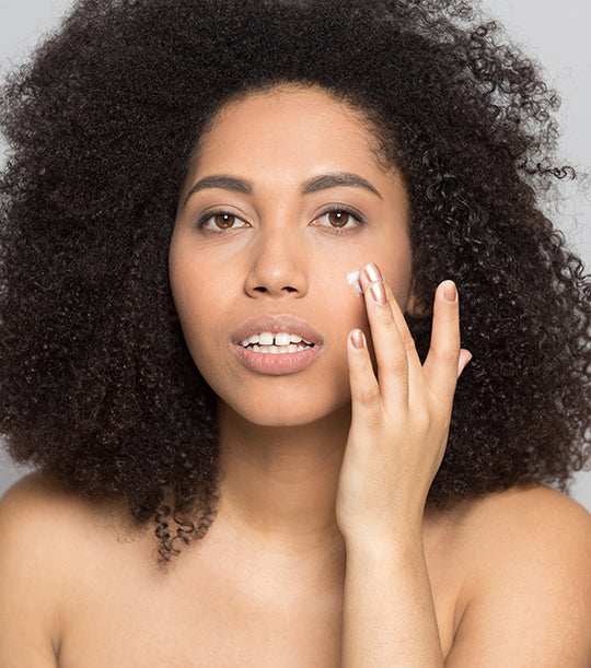 Model applying a cream to her face.