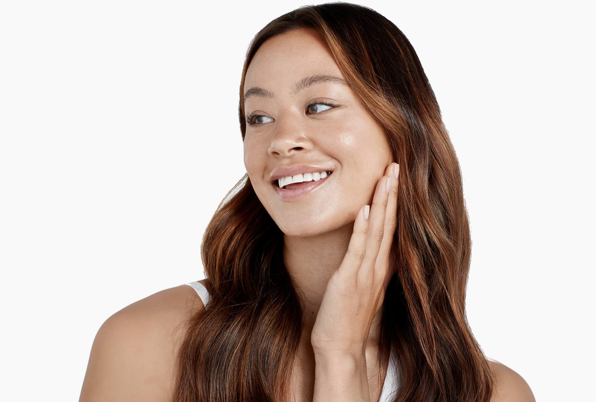 Woman smiling touching her face.
